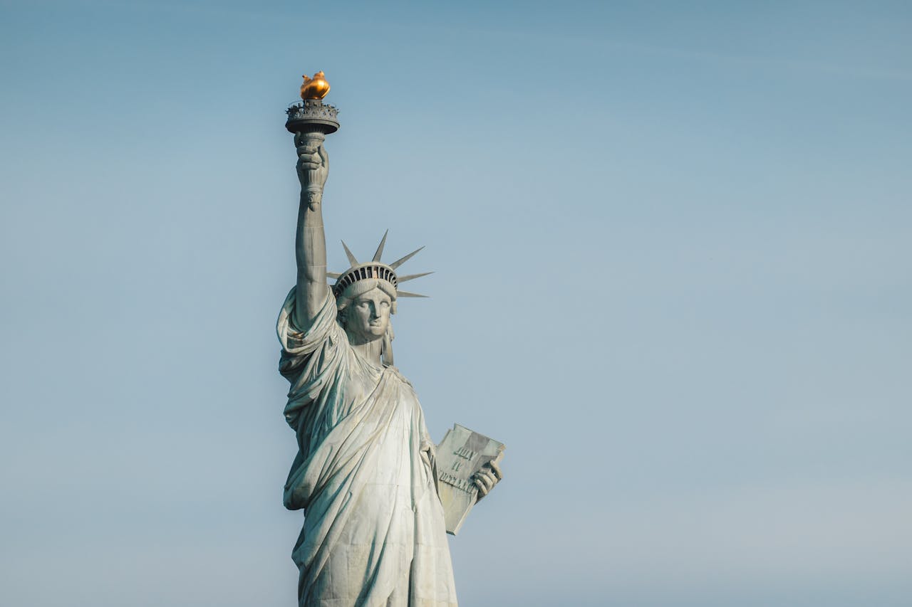 Iconic Statue of Liberty in New York City on a clear day, symbolizing freedom and democracy.